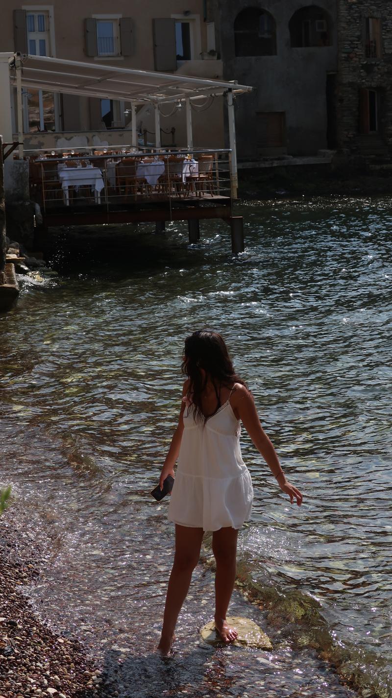 Femme marchant dans l’eau devant un restaurant