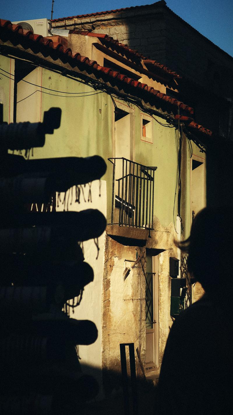 Façade et balcon en contre-jour, silhouette au premier plan
