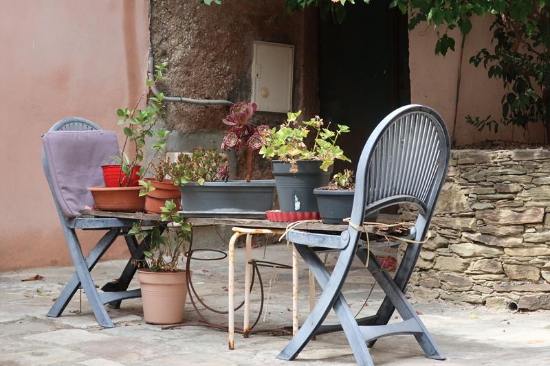 Patio fleuri avec chaises bleues