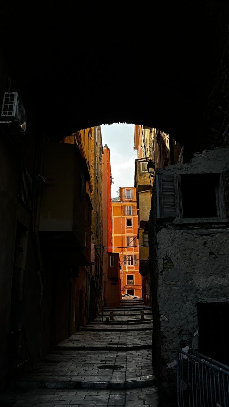 Passage voûté ouvrant sur une rue colorée